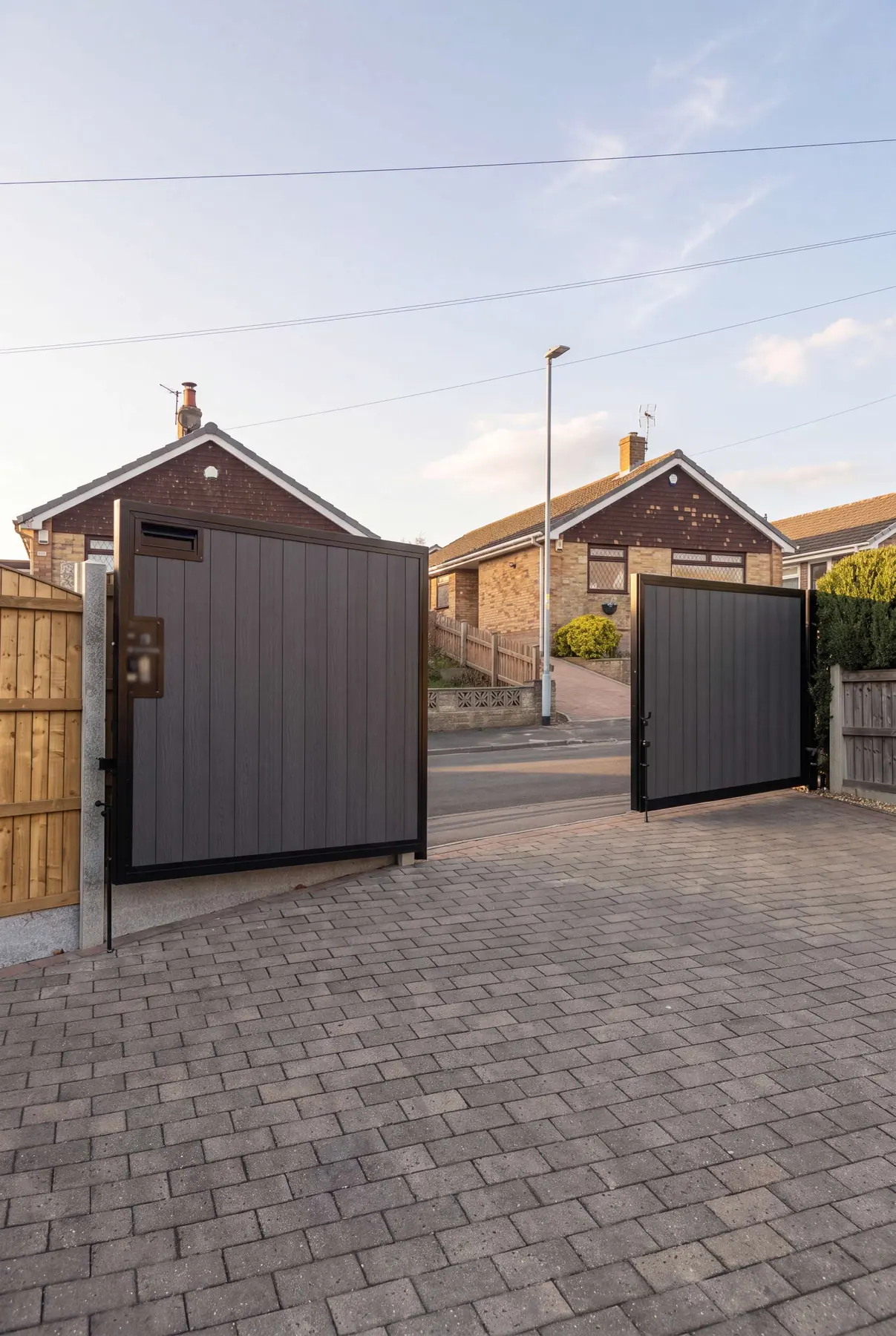 Dark composite manual gates at a Yorkshire bungalow
