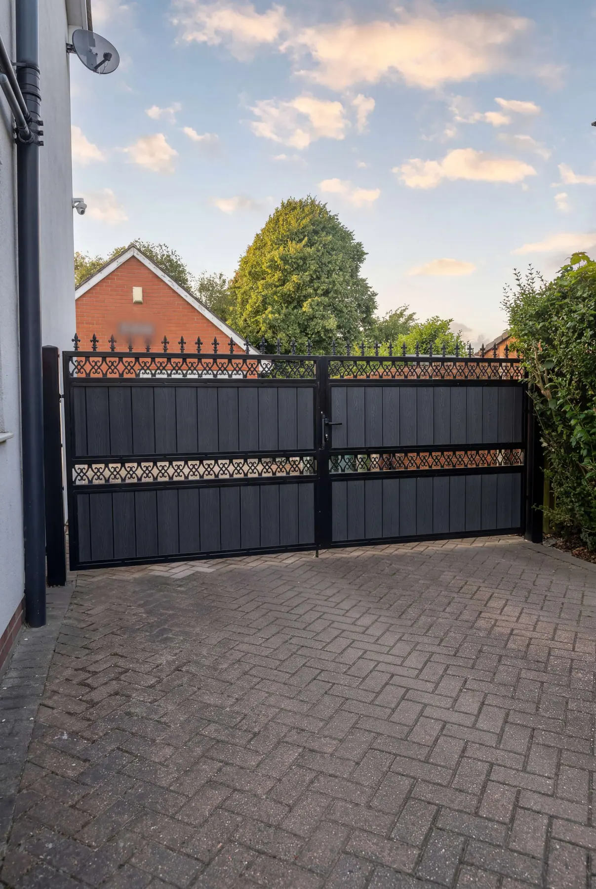 Manual gates with a bronze lattice band and spear-topped railings